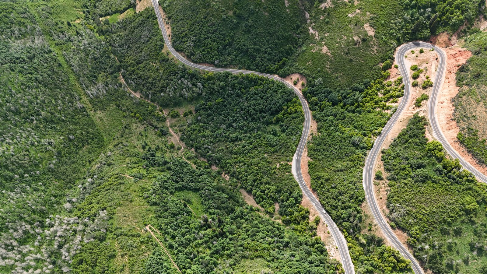 Aerial view of a winding mountain road disappearing around a bend